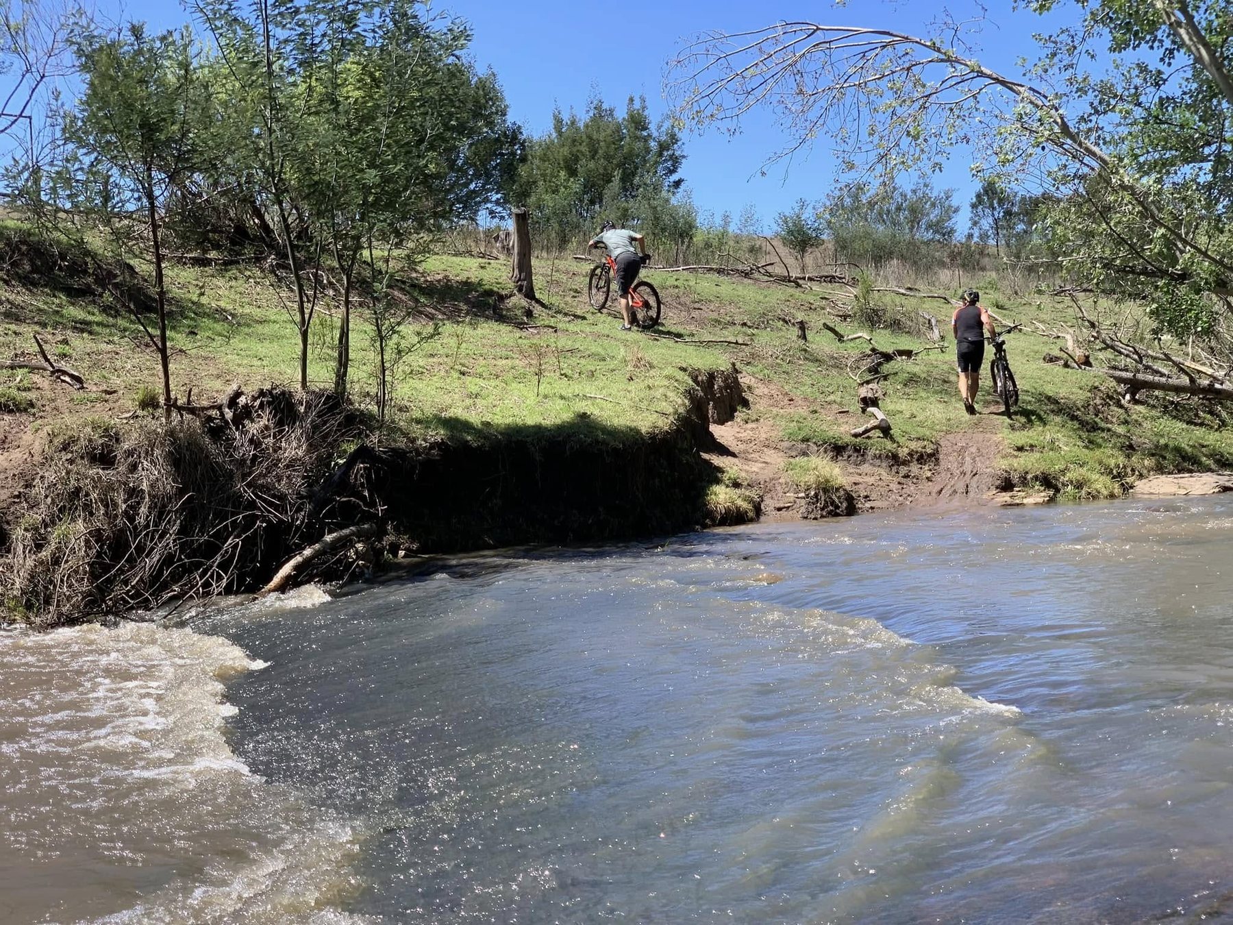 Mountain bikers crossing a river at Thomas River